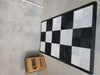 Interlocking floor tile mat with black-and-white checker pattern on flat surface
