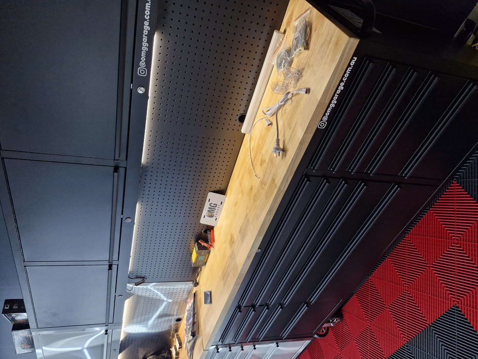 Black workshop command centre with countertop work surface, tool storage, and pegboard