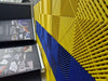Blue and yellow interlocking garage floor tiles with raised ventilation ridges