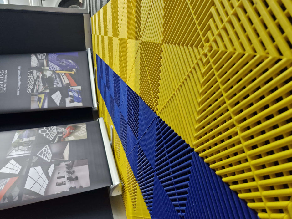 Blue and yellow interlocking garage floor tiles with raised ventilation ridges
