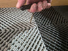 Tile removal tool with long metal rod prying between floor slats