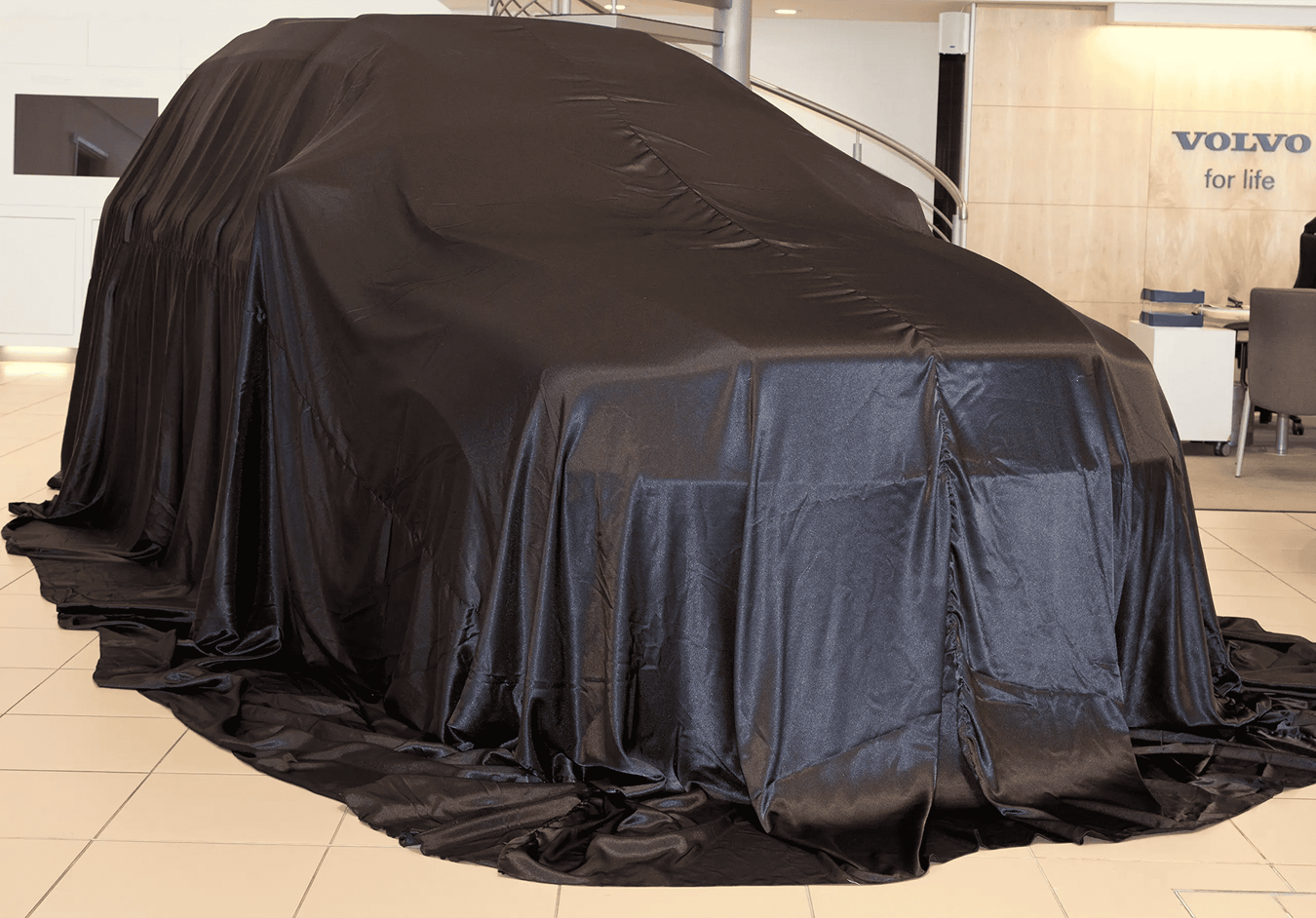 Black car reveal cover draped over a vehicle, covering hood and full sides.