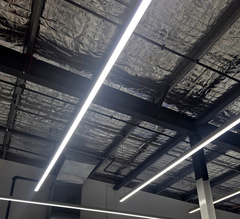 Straight LED linear light bars on ceiling with bright white glow
