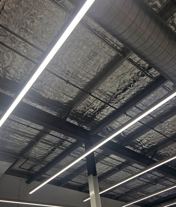Bright white LED linear light bar on ceiling with mounting brackets