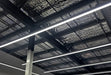 Multiple straight LED linear light bars on ceiling with bright white strips